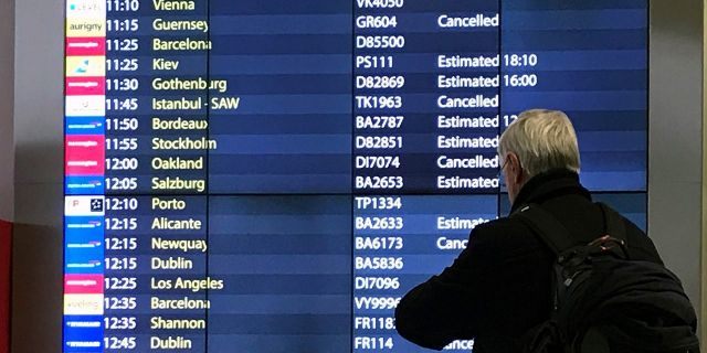 A passenger checks an arrivals board at Gatwick Airport in England, Friday, Dec. 21, 2018. (AP Photo/Kirsty Wigglesworth)