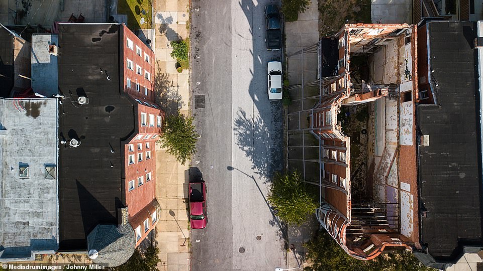 Miller, who was born in the States but now lives in South Africa, has captured pockets of disparity across the country. Pictured are homes on opposite sides of the street in Baltimore, where one apartment building has been completely gutted, leaving nothing more than its outer shell