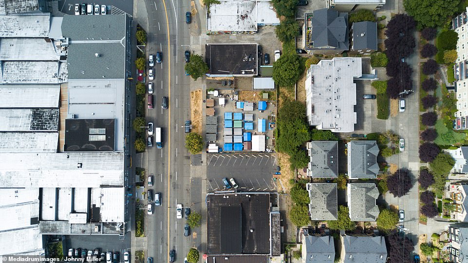 Johnny Miller has taken a series of searing aerial photos revealing gross inequality across America where rich and poor live side-by-side. Pictured here, surrounded on either side by nice, expensive homes, sits Seattle's Tent City