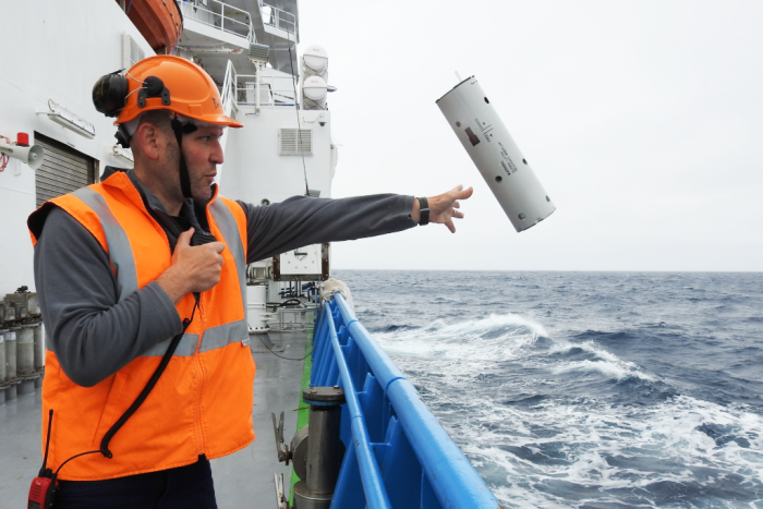 Brian Miller deploying a sonobuoy listening device off the Investigator near Antarctica