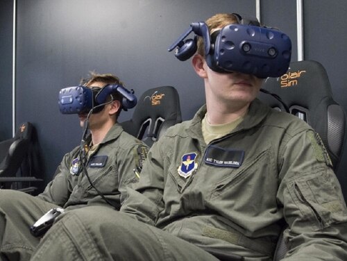 Second Lt. Charles Keller and Airman First Class Tyler Haselden, Pilot Training Next students, train on a virtual reality flight simulator at the Armed Forces Reserve Center in Austin, Texas, June 21. The Air Education and Training Command initiative aims to explore and prototype a training environment that integrates various technologies to produce pilots in an accelerated, cost-efficient manner. (Sean Worrell/Air Forcce)