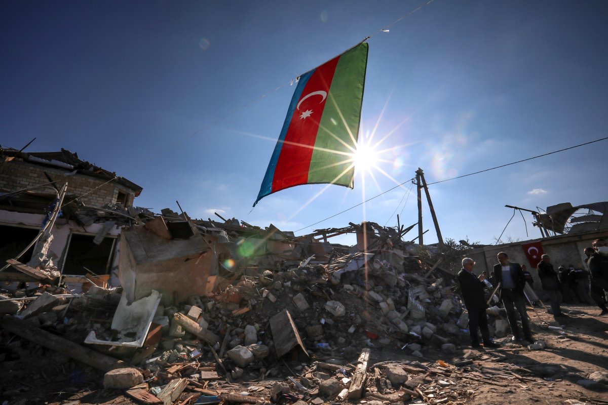 Azerbaijan’s national flag flies over destroyed houses in a residential area that was hit by rocket fire overnight by Armenian forces, on Oct. 22, 2020 in Ganja, Azerbaijan’s second largest city, near the border with Armenia.