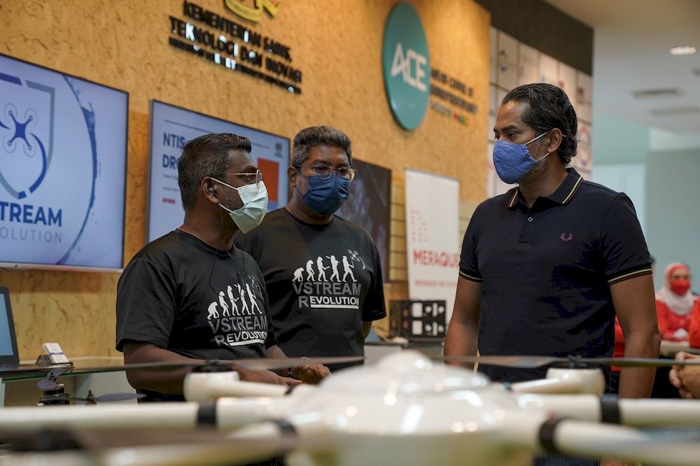 Khairy chats to drone operators from VStream Revolution, one of the two Malaysian companies chosen to test out the pilot project. — Picture courtesy of MaGIC