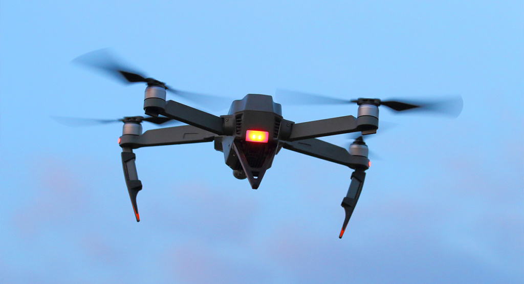 A black spying drone on the evening sky