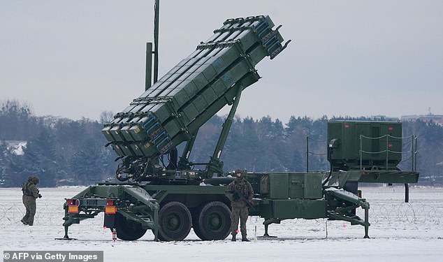 A soldier stands in front of a PATRIOT (Phased Array Tracking Radar to Intercept on Target) surface-to-air missile system during a military exercise at Warsaw Babice Airport, Poland