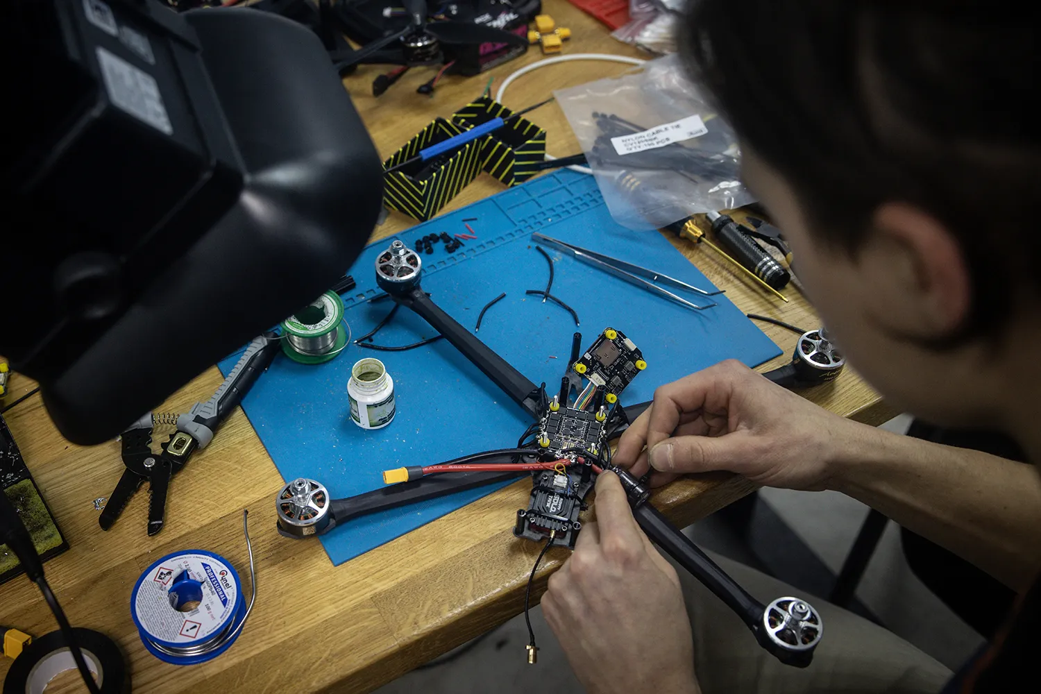 An employee puts together intricate pieces of a drone for military use.